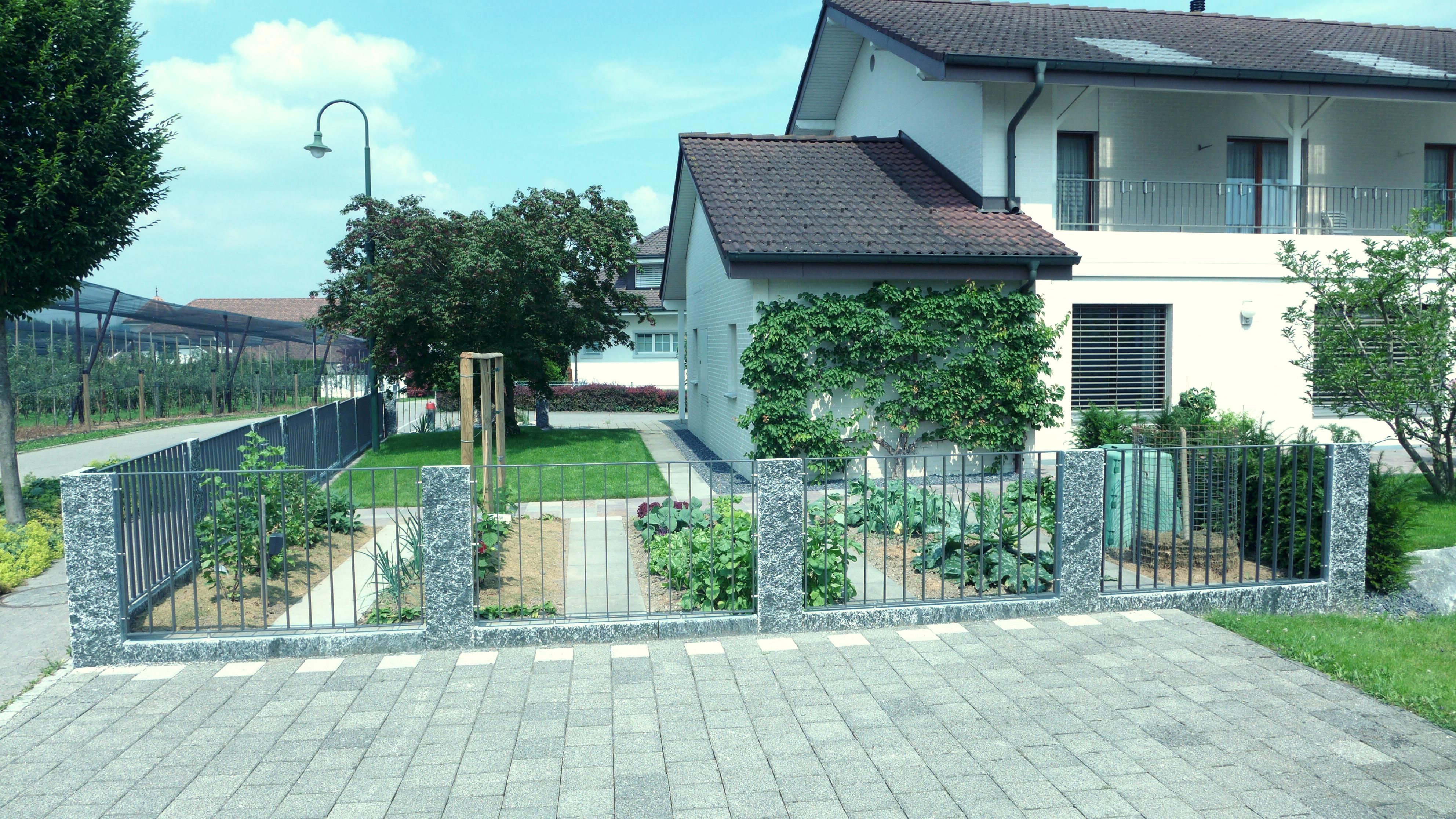 Laederach Gartenbau - Gartenzaun mit Granitpalisaden und Metallzaun